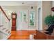 Foyer with white front door, hardwood floors, grandfather clock, and fern on a stand at 707 Royall Ave, Mount Pleasant, SC 29464