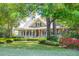 Picturesque home with a sprawling lawn, vibrant azaleas, and a classic covered front porch at 707 Royall Ave, Mount Pleasant, SC 29464