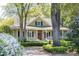 Inviting home with a spacious front porch, wood door, and lush landscaping at 707 Royall Ave, Mount Pleasant, SC 29464