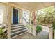 Inviting covered porch with wooden railings and steps, complemented by lush greenery at 707 Royall Ave, Mount Pleasant, SC 29464