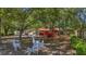 Large, tree-shaded backyard with deer lawn art, a red trailer, and potential for outdoor activities at 1010 Black Oak Rd, Bonneau, SC 29431