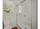 Bathroom featuring white tile shower with glass doors, white fixtures and wood floors at 1010 Black Oak Rd, Bonneau, SC 29431