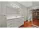 Bathroom featuring long white vanity with storage, wood floors, and exposed brick accent wall at 1010 Black Oak Rd, Bonneau, SC 29431