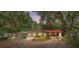 Charming single-story home featuring a red roof, covered parking, and a well-manicured front yard surrounded by lush trees at 1010 Black Oak Rd, Bonneau, SC 29431