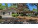 Charming home with a red roof and cozy front porch, surrounded by vibrant landscaping and mature trees at 1010 Black Oak Rd, Bonneau, SC 29431
