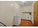 Laundry area with wood floors, sink with cabinet, and exposed pipes at 1010 Black Oak Rd, Bonneau, SC 29431