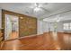 Bright and open living room featuring hardwood floors, a brick accent wall, and seamless flow into other spaces at 1010 Black Oak Rd, Bonneau, SC 29431