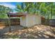 Tan storage shed in fenced backyard with covered area, providing outdoor storage at 1010 Black Oak Rd, Bonneau, SC 29431