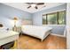 Bedroom featuring blue walls, wood floors, a white bed and a window with blinds at 1116 Daffodil Ln, Mount Pleasant, SC 29464