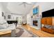Bright and airy living room featuring a fireplace, wood floors, and vaulted ceilings with a skylight at 1116 Daffodil Ln, Mount Pleasant, SC 29464