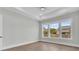 Bedroom with hardwood floors and three large windows that let in plenty of natural light at 1159 Reserve Ln, Awendaw, SC 29429