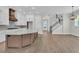 Open concept kitchen with white cabinets, a large island, and modern appliances next to the staircase at 1159 Reserve Ln, Awendaw, SC 29429