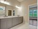 Bathroom featuring double vanity sinks, lighting fixtures, and a large mirror at 1212 Reserve Ln, Awendaw, SC 29429