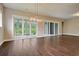 Hardwood floor dining room with contemporary chandelier, with large glass doors accessing outdoor space at 1212 Reserve Ln, Awendaw, SC 29429
