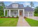 Charming gray home with a welcoming front porch and attached two-car garage with an elongated driveway at 1212 Reserve Ln, Awendaw, SC 29429