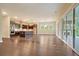 Open-concept living area with brick accents in the kitchen, hardwood floors, and access to an outdoor patio at 1212 Reserve Ln, Awendaw, SC 29429