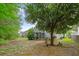 A backyard featuring a spacious lawn, mature trees, and a screened porch at 1216 Wild Goose Trl, Summerville, SC 29483