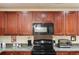 Modern kitchen features sleek black appliances, granite countertops and stylish cherry wood cabinetry at 1216 Wild Goose Trl, Summerville, SC 29483