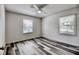 Bright bedroom with ceiling fan, two windows, and modern gray and white hardwood flooring at 1232 Hawthorne Cir, Hanahan, SC 29410