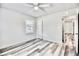 Bright bedroom with ceiling fan, window, closet, and modern gray and white hardwood flooring at 1232 Hawthorne Cir, Hanahan, SC 29410