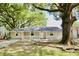Charming single-story home featuring a covered front porch and mature shade trees in a tranquil setting at 1232 Hawthorne Cir, Hanahan, SC 29410