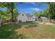 This backyard features a fire pit, swing set, and white siding on a home surrounded by lush trees and green grass at 1260 Old Whitesville Rd, Moncks Corner, SC 29461