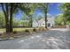 Backyard with a partial view of home, featuring mature trees, a gravel driveway, and lush landscaping at 1260 Old Whitesville Rd, Moncks Corner, SC 29461