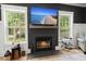 Close up of a fireplace in a living room with a wall-mounted TV and natural light at 1260 Old Whitesville Rd, Moncks Corner, SC 29461