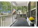 Charming front porch featuring a swing and an American flag, creating a welcoming outdoor space at 1260 Old Whitesville Rd, Moncks Corner, SC 29461