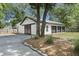 Three car garage with a three black doors and gravel driveway, complemented by landscaped features at 1260 Old Whitesville Rd, Moncks Corner, SC 29461