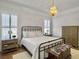 Bedroom with a metal frame bed, wooden bedside tables, and a decorative chandelier at 127 Beresford Creek St, Daniel Island, SC 29492