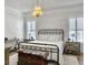 Bright bedroom features a metal bed frame, chandelier, and neutral tones at 127 Beresford Creek St, Daniel Island, SC 29492