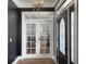 Elegant entryway with hardwood floors, chandelier, french doors and decorative front door at 127 Beresford Creek St, Daniel Island, SC 29492