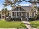 Charming blue two-story home featuring a welcoming front porch and lush, landscaped yard at 127 Beresford Creek St, Daniel Island, SC 29492