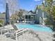A refreshing pool area with lounge chairs and view of house with screened porch at 127 Beresford Creek St, Daniel Island, SC 29492