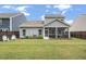 Well-maintained backyard featuring a screened in porch, green lawn, and mature trees for privacy at 127 Surfbird Rd, Summerville, SC 29486
