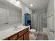 Well-lit bathroom featuring a white vanity sink, toilet, and shower with a blue accent cabinet at 127 Surfbird Rd, Summerville, SC 29486