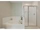 Well lit bathroom offers a soaking tub with shower and glass enclosed shower stall at 127 Surfbird Rd, Summerville, SC 29486