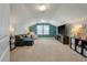 Spacious bonus room with large TV, lounge furniture and a stylish accent wall at 127 Surfbird Rd, Summerville, SC 29486