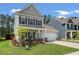 Charming two-story home with a manicured front yard, covered porch, and attached garage, offering curb appeal at 127 Surfbird Rd, Summerville, SC 29486