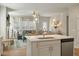 Bright kitchen boasts white cabinets, quartz countertops, and stainless steel appliances, flowing into the living area at 127 Surfbird Rd, Summerville, SC 29486
