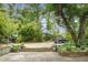 A brick patio and mature trees frame a lush backyard with plenty of space for outdoor entertaining at 1316 Wichman St, Walterboro, SC 29488
