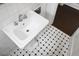 Close-up on a pedestal sink with tiled backsplash and patterned floor at 1316 Wichman St, Walterboro, SC 29488