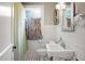 Bright bathroom features tiled walls, patterned floors, pedestal sink, and a window at 1316 Wichman St, Walterboro, SC 29488