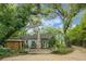 A cottage style house showing mature trees, flowers, and a brick chimney at 1316 Wichman St, Walterboro, SC 29488