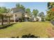 Expansive backyard with lush lawn, patio, and covered porch, ideal for outdoor living at 1505 Rivertowne Country Club Dr, Mount Pleasant, SC 29466