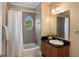 Charming bathroom featuring a tub with shower and an oval window letting in natural light, complemented by a stylish vanity at 1505 Rivertowne Country Club Dr, Mount Pleasant, SC 29466