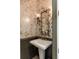 Charming powder room features unique vanity with gold fixtures and decorative mirror with a leaf design at 1505 Rivertowne Country Club Dr, Mount Pleasant, SC 29466