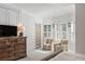 Light filled primary bedroom showcases shuttered windows, sitting area, and large dresser at 1505 Rivertowne Country Club Dr, Mount Pleasant, SC 29466