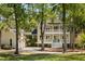 Elegant home featuring a two-story facade with a lush lawn and mature trees at 1505 Rivertowne Country Club Dr, Mount Pleasant, SC 29466